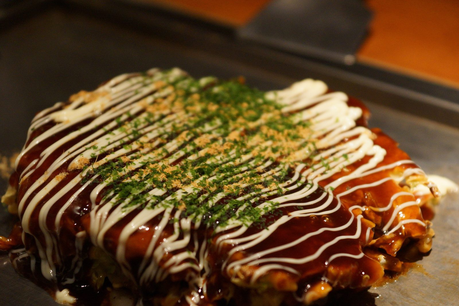 Okonomiyaki on the teppan with sauce and mayonnaise